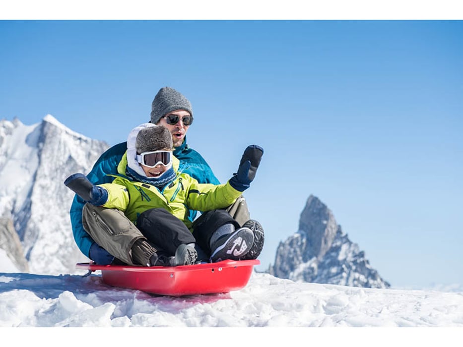 father and child riding sled