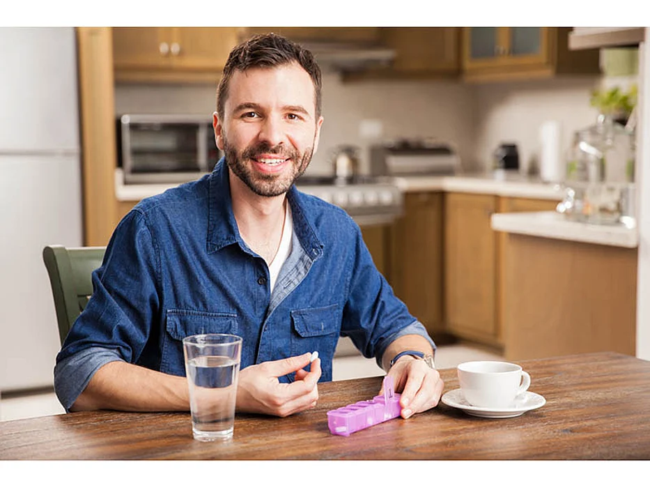 man taking his pill and smiling
