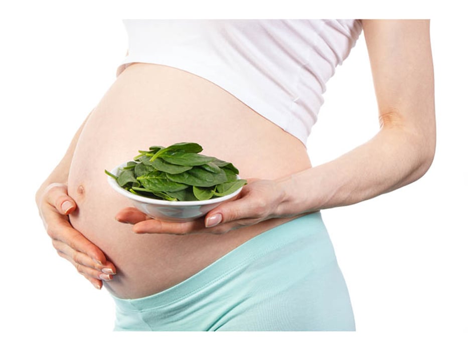 pregnant woman with a spinach bowl