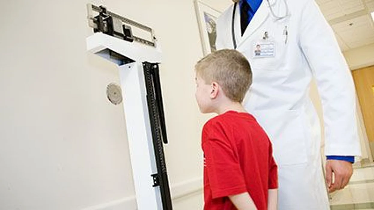 a boy on a scale in a doctor office