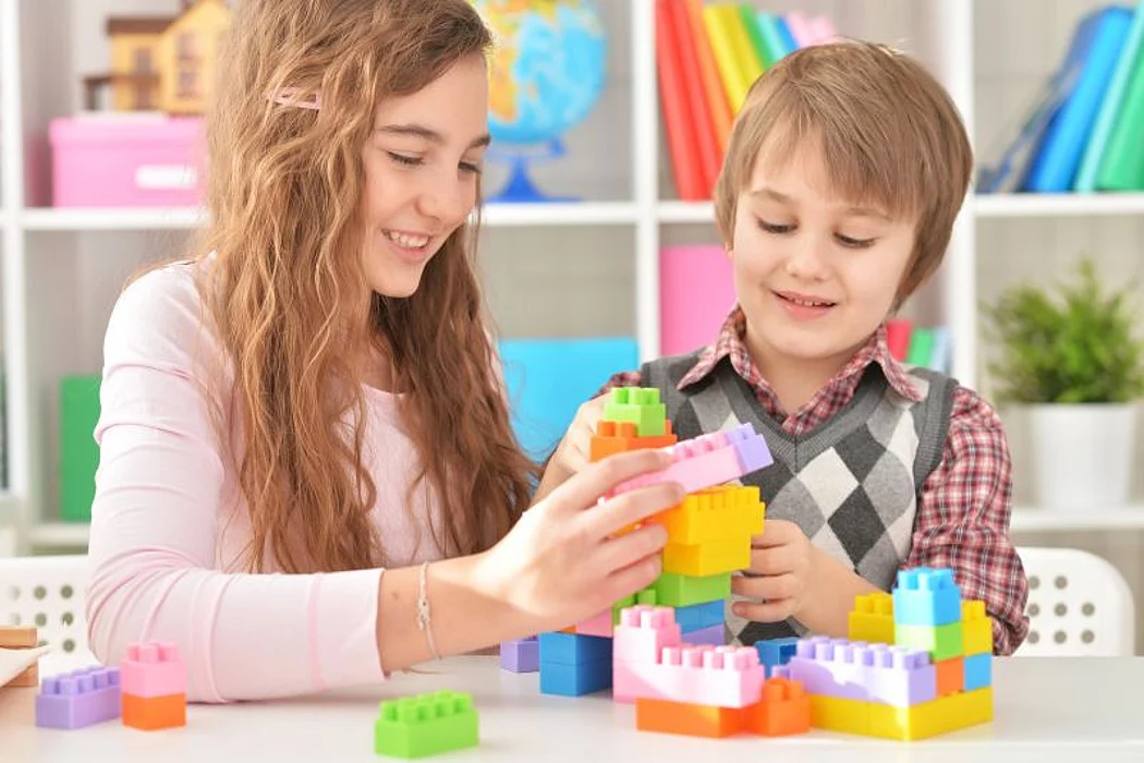 a boy and a girl playing with lego blocks