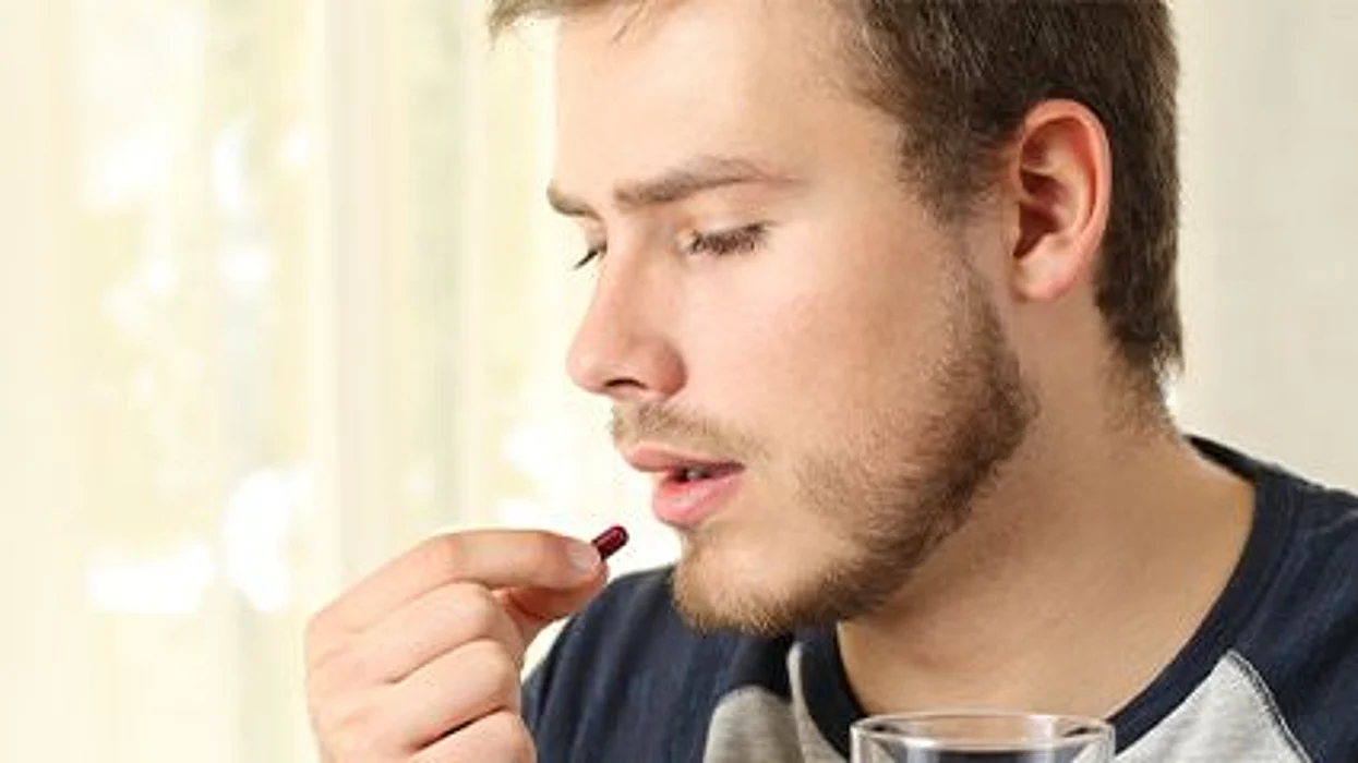 a man taking a pill