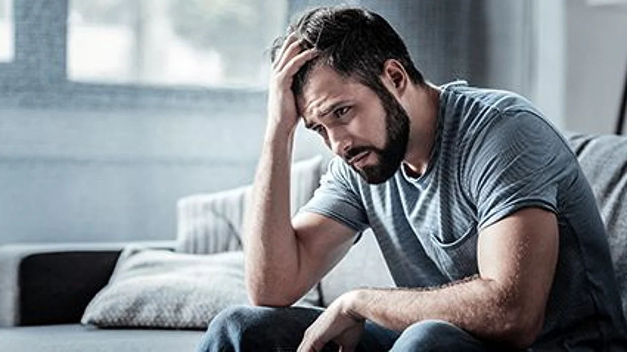 a man holding his head looking stressed