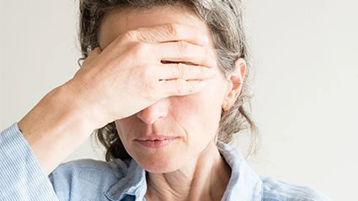 older woman holding her head