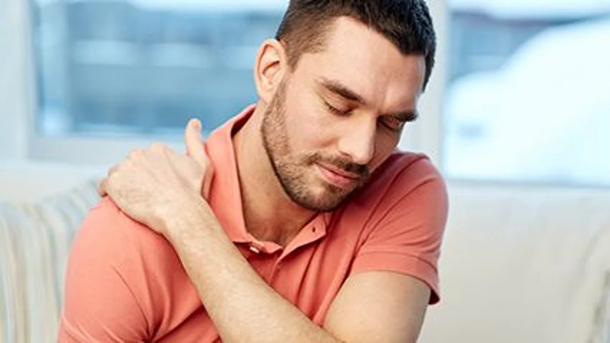 a man holding his shoulder in pain