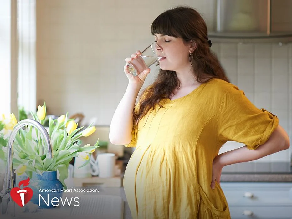 a pregnant woman drinking water from a glass