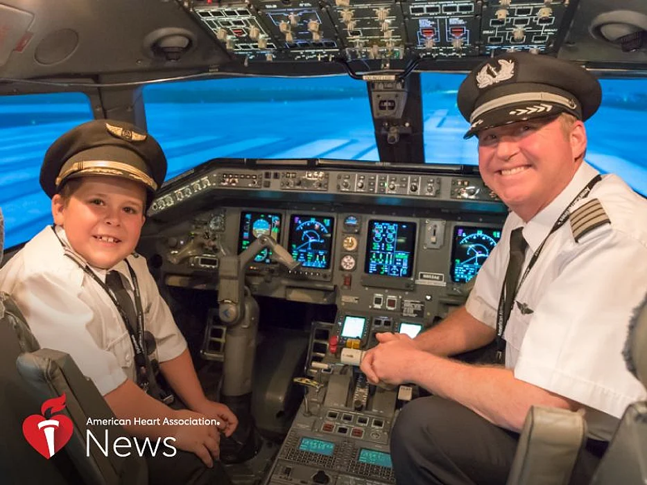 Easton Fryer in a flight simulator with Ric Wilson, vice president of flight operations for Envoy Air.