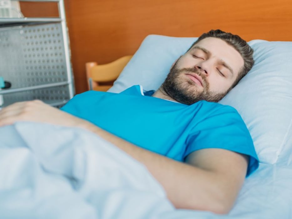 man sleeping in hospital bed