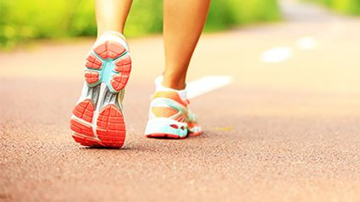 a person\'s feet walking wearing sneakers