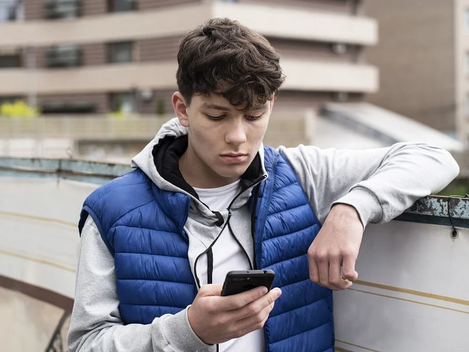 sad teen boy texting