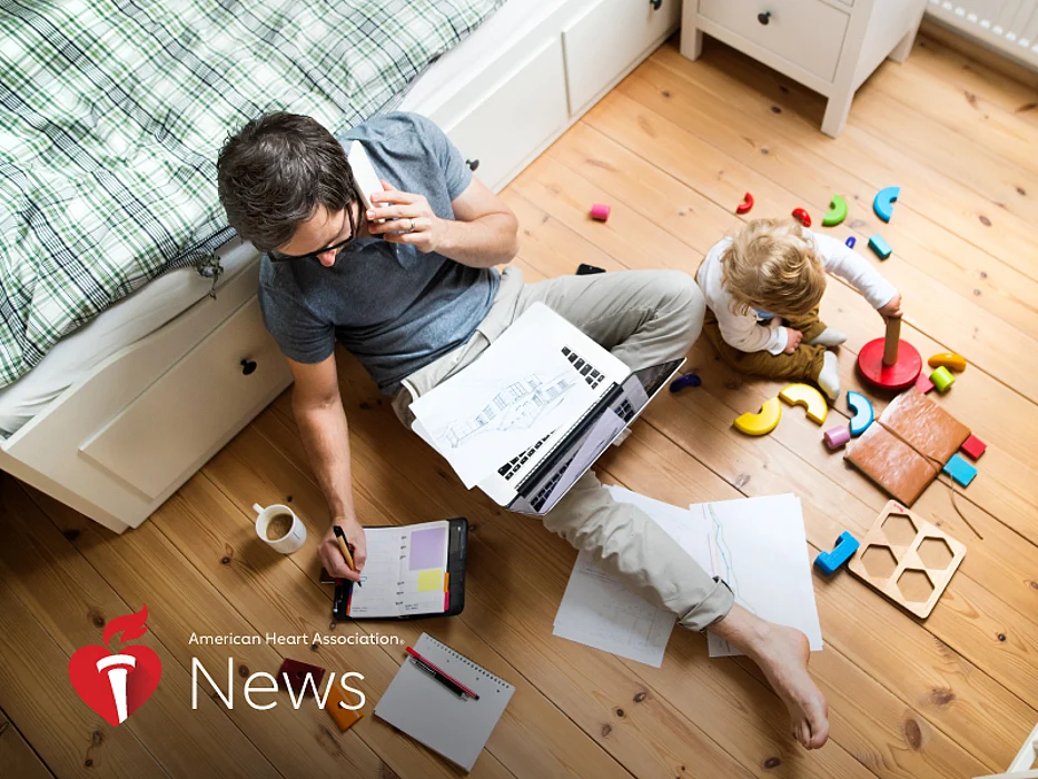 a man on a a laptop and a baby playing