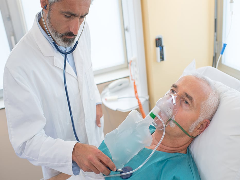 old male patient lying on hospital bed with oxygen mask