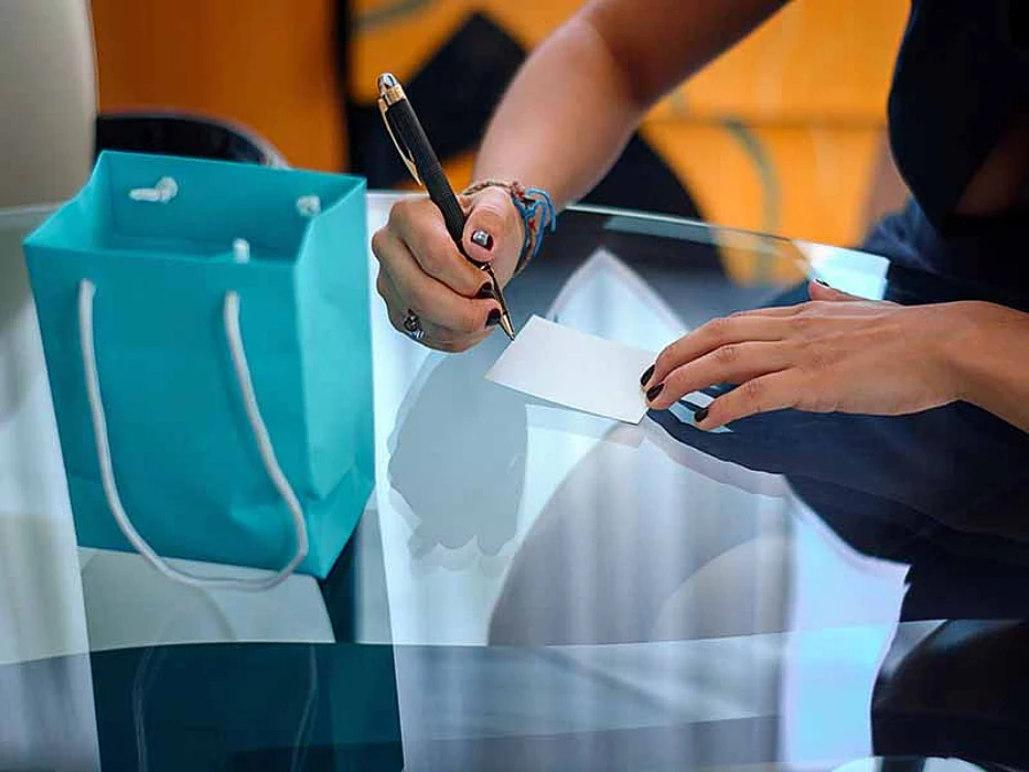 Female hand writes a note on a glass table