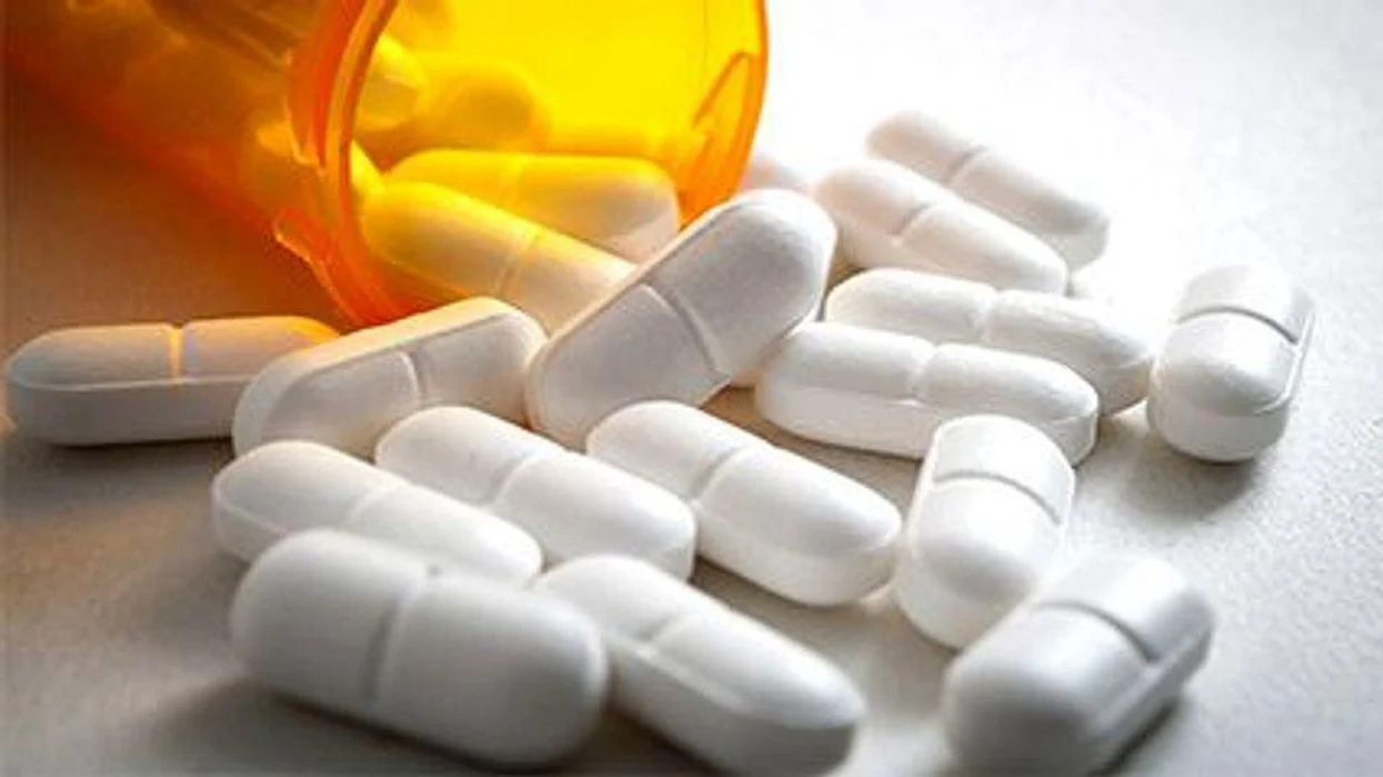large white pills and a medicine bottle