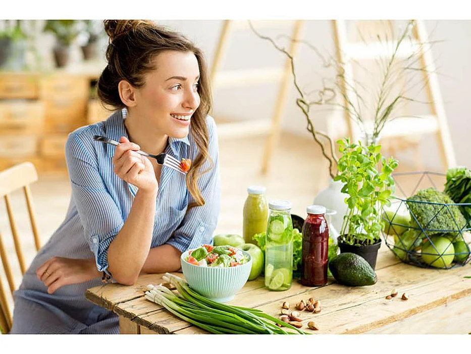 woman smiling and eating a healthy salad