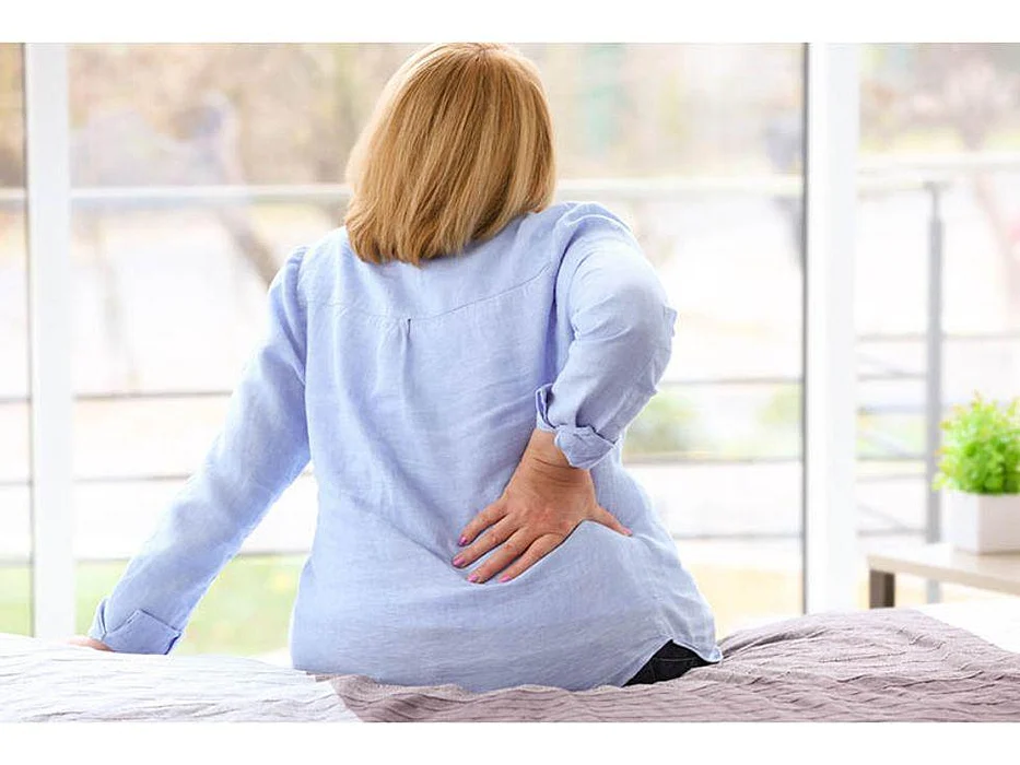 woman holding her back in pain