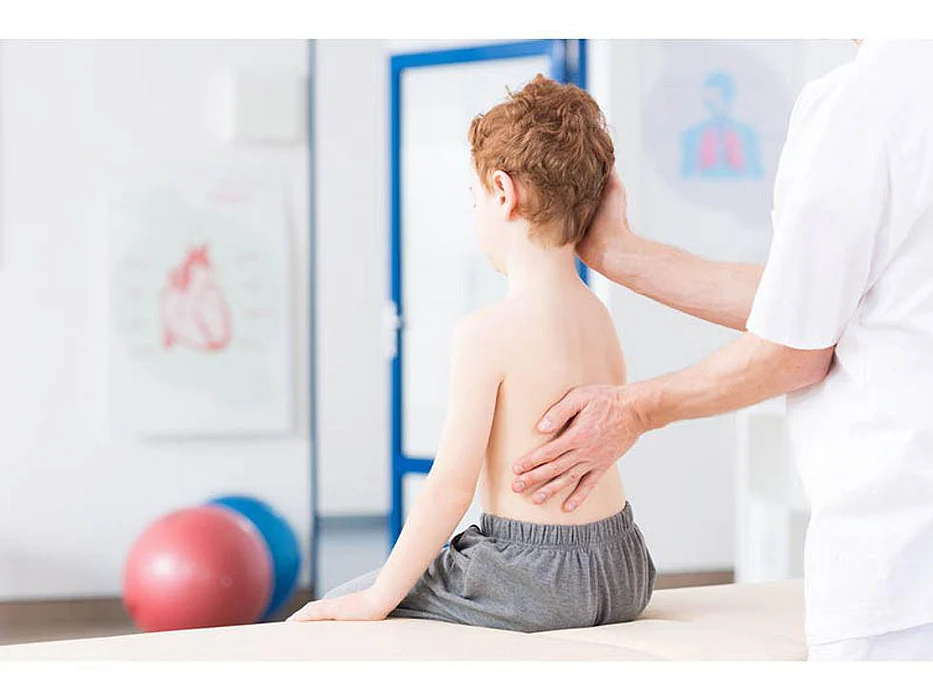 doctor checking girl for scoliosis