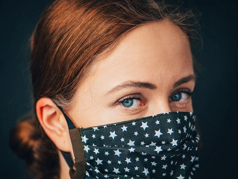 redhead woman wearing blue face mask with white stars