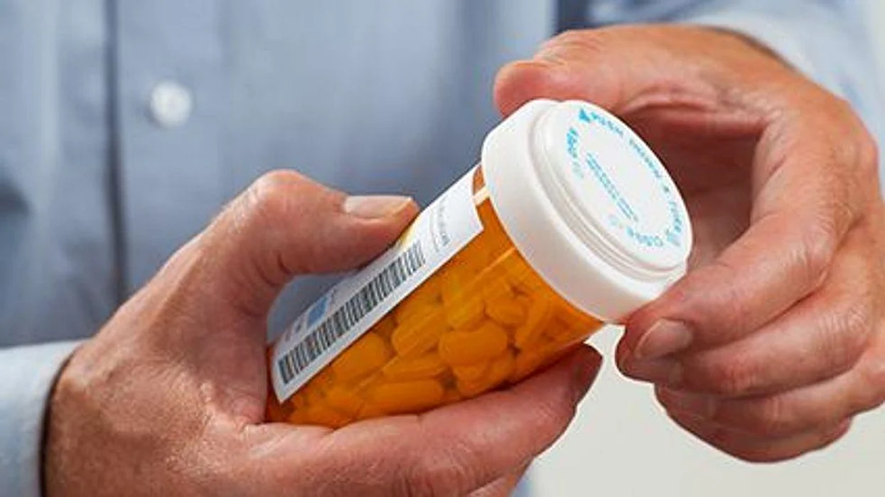 a person holding a medication bottle