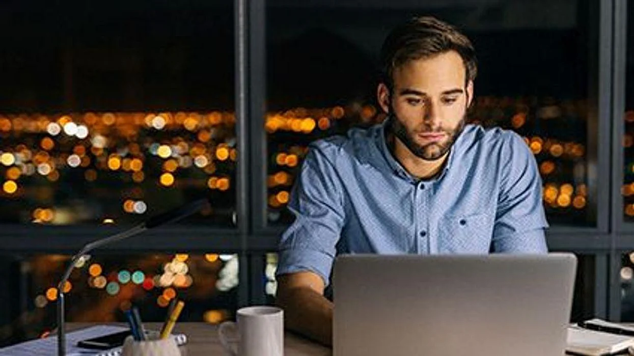 a man sitting at the computer late at night