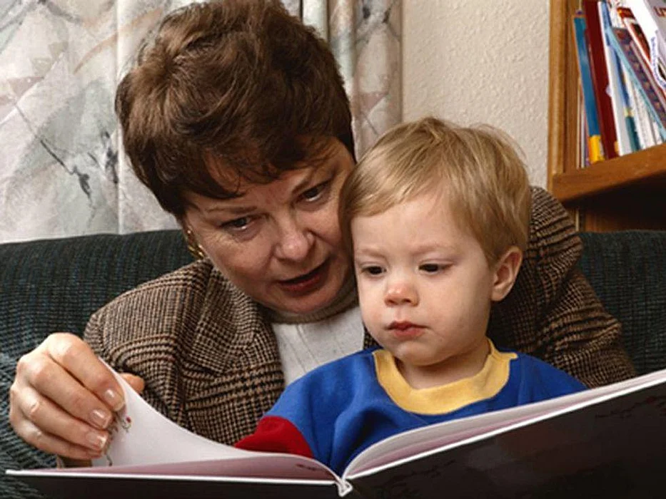 kid with a woman reading books