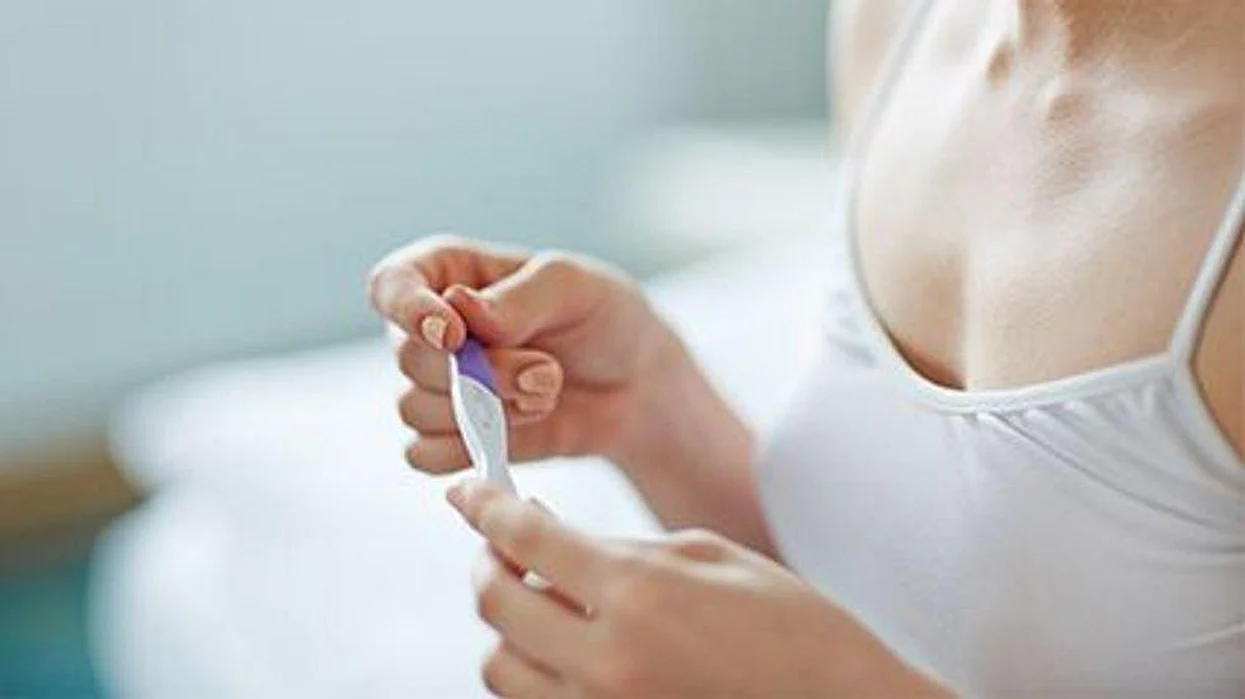 a woman looking at the pregnancy test