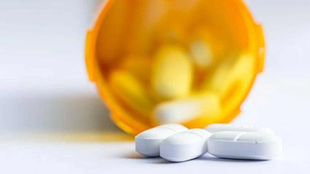 a medicine bottle with pills spilled out of it