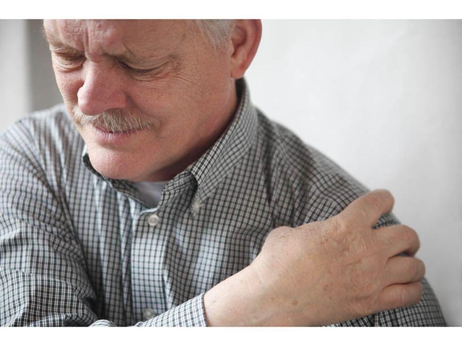man holding his shoulder with pain
