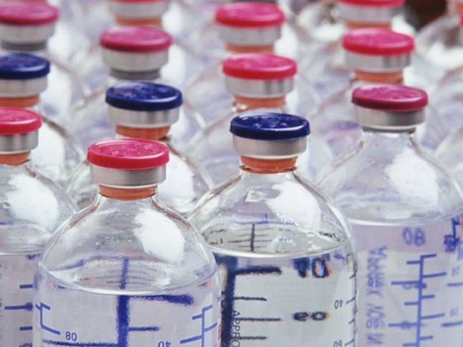 glass bottles of vaccine liquid with pink and blue caps
