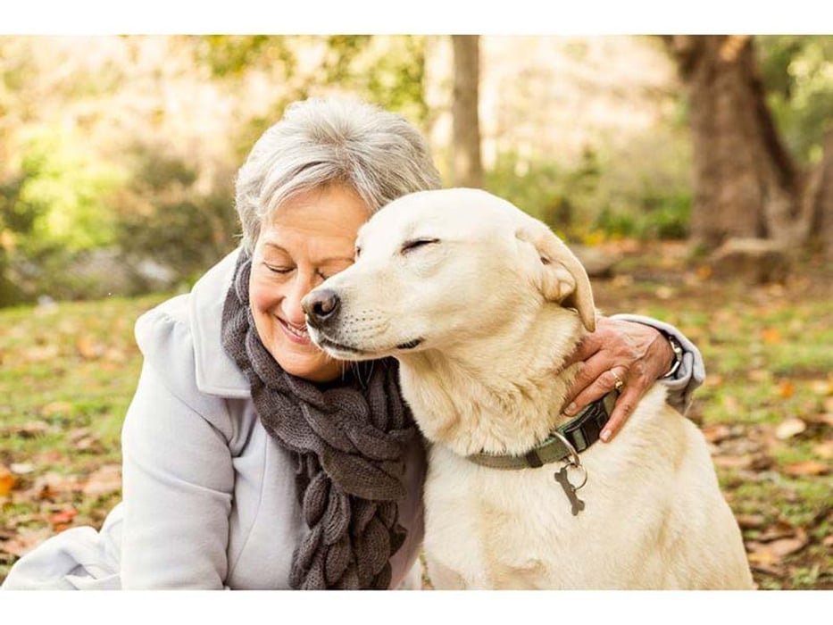 older woman hugging a dog