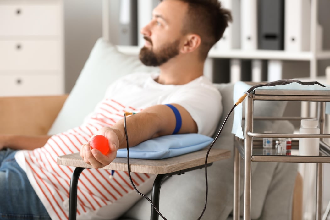 Man with grip ball donating blood in hospital