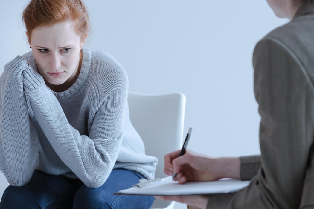 Sad young woman with eating disorders during meeting with psychotherapist anorexia