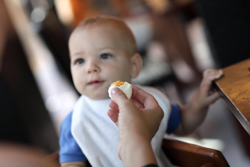 Toddler eating boiled egg
