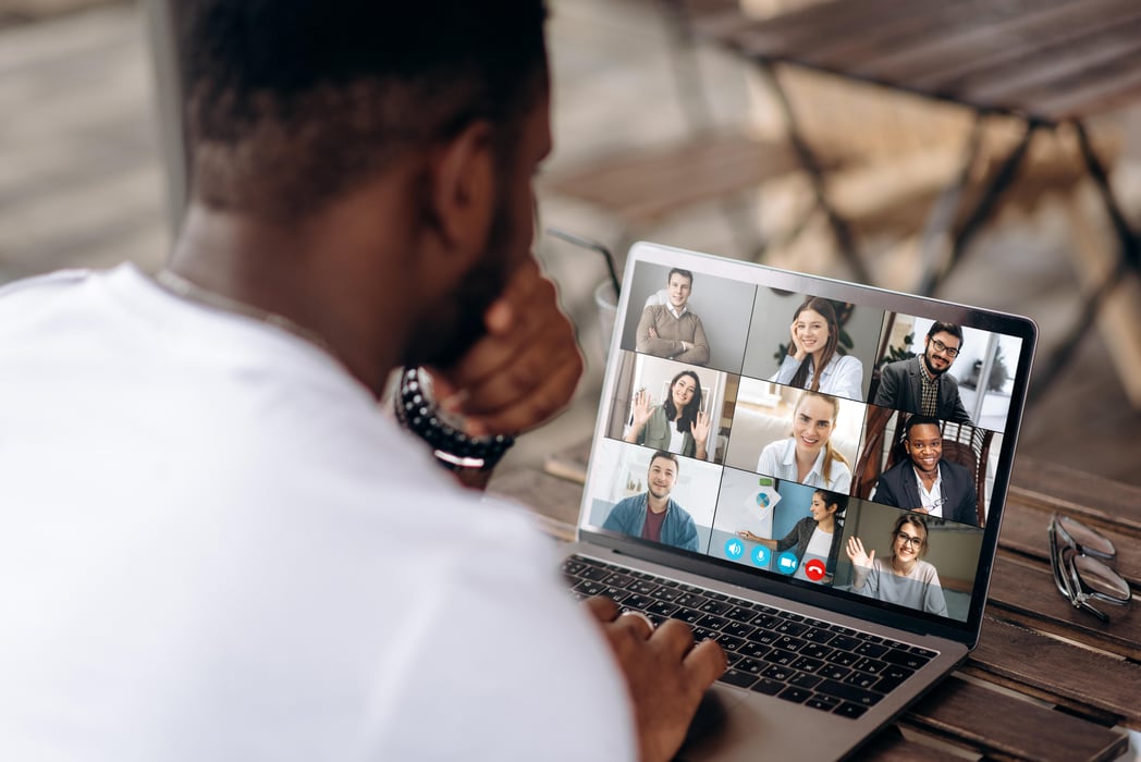 Zoom call business meeting Video call. Video conference. Successful African American freelancer communicate by a video conference with his colleagues using a laptop while sitting in cafe in a summer terrace