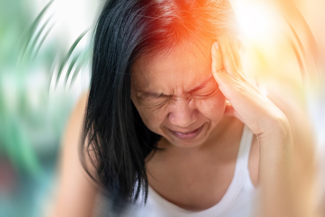 Vertigo illness concept. Woman hands on his head felling headache dizzy sense of spinning dizziness,a problem with the inner ear, brain, or sensory nerve pathway.