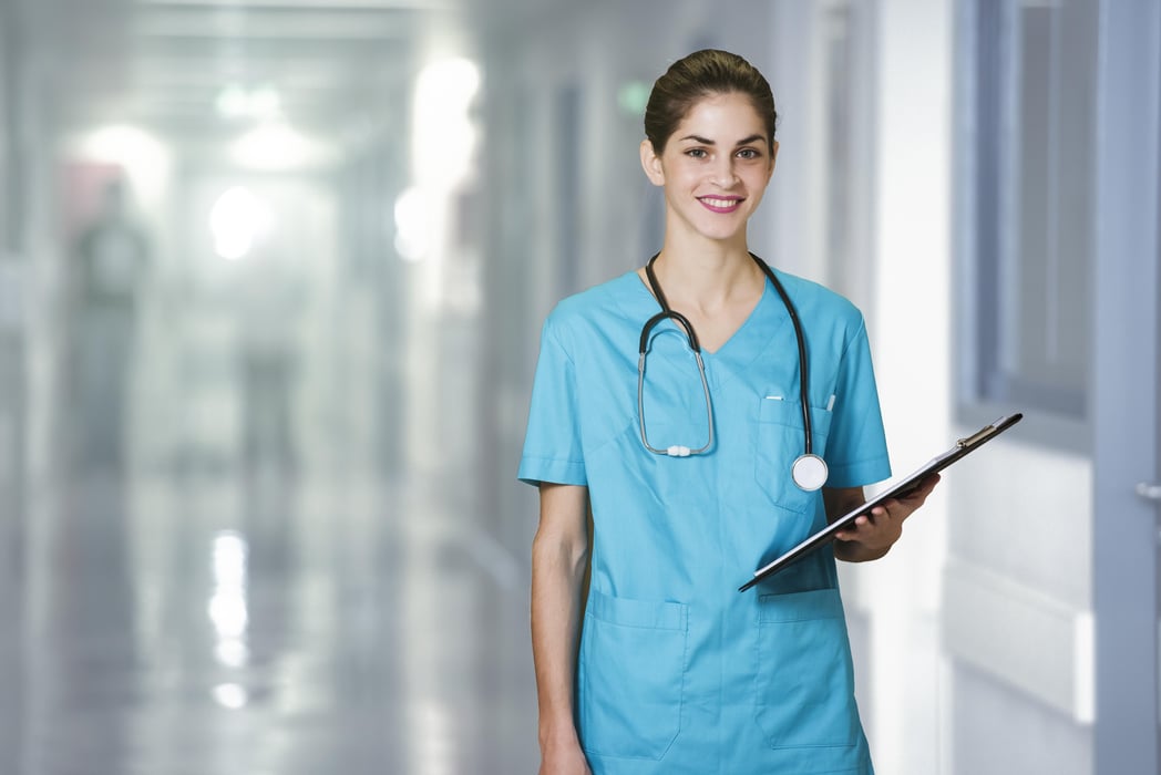 woman doctor or nurse standing in hospital corridor