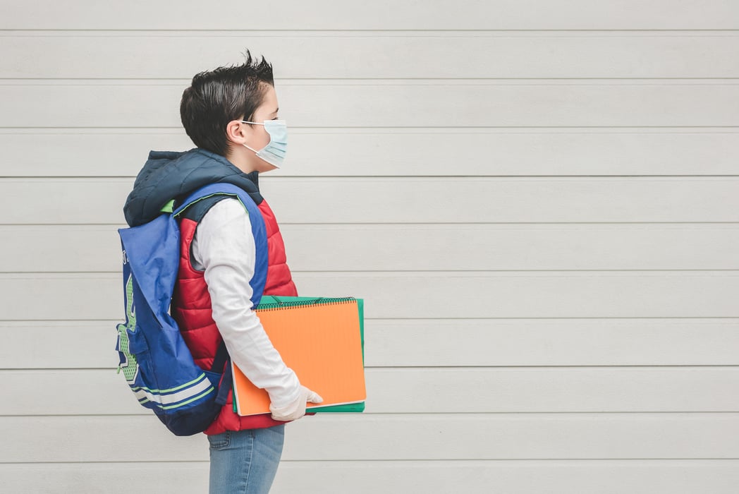 kid with medical mask and backpack going to school