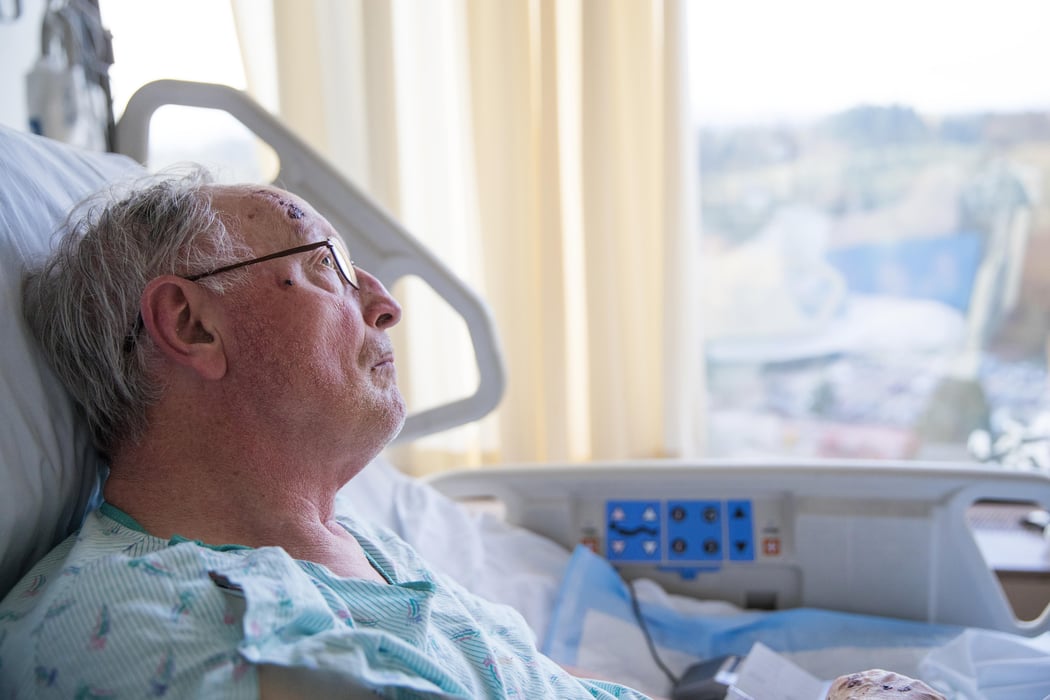 Old man in hospital bed looking up