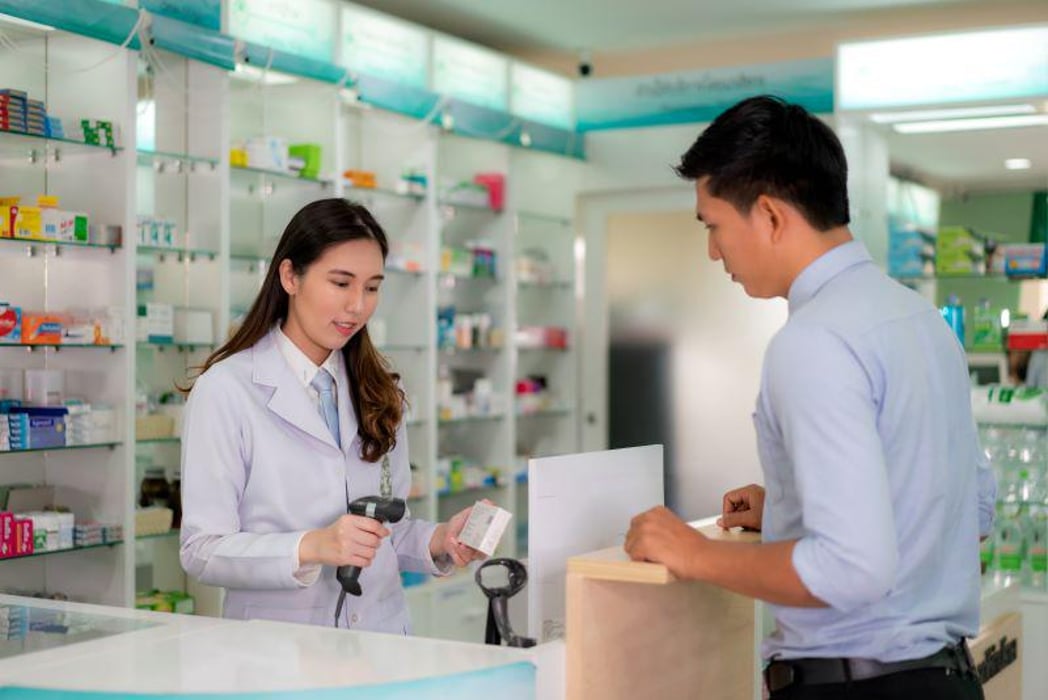 pharmacist in pharmacy scanning price of medication