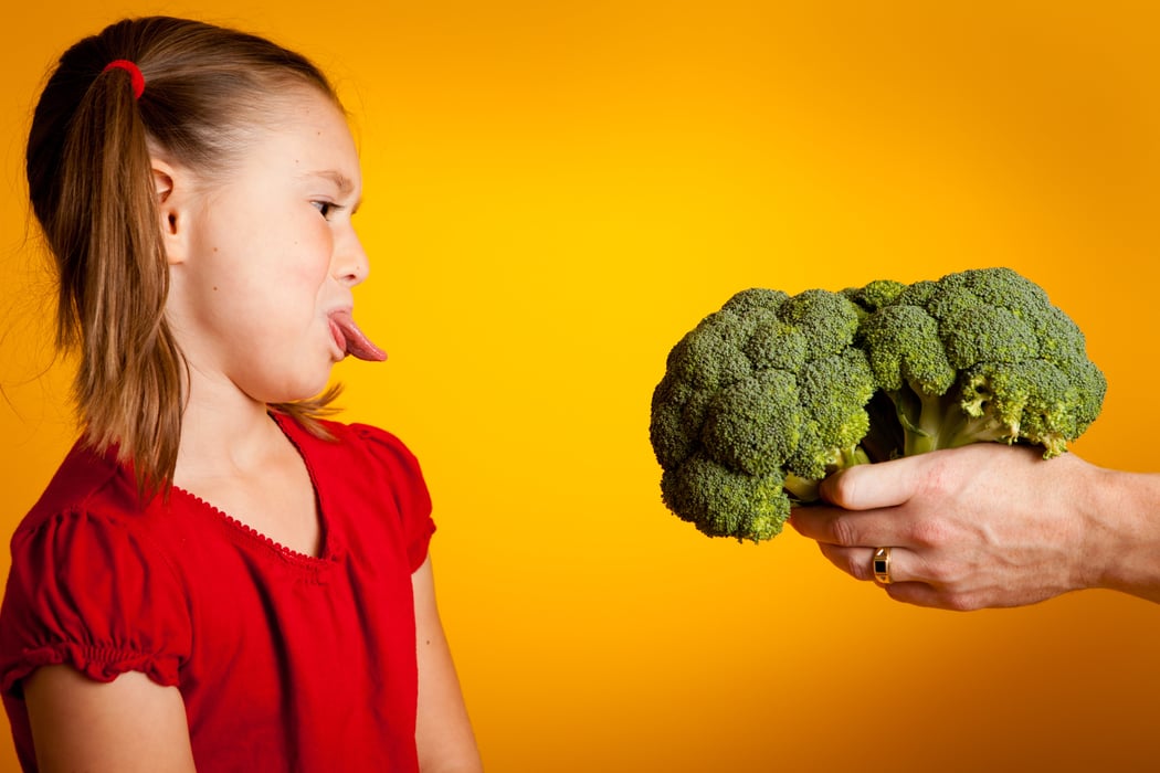 girl sticking tongue out at a vegetable kids eating vegetables